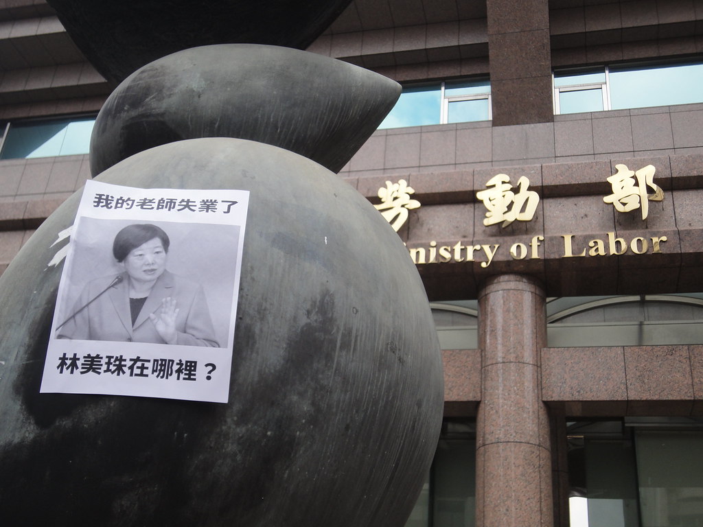 學團在勞動部前雕像貼上協尋李美珠的傳單。（攝影：張智琦）