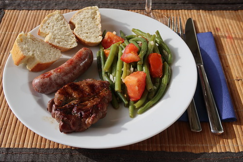 Wildschwein-Nackensteak und Wild-Bratwürstchen zu Bohnen-Tomaten-Salat und frisch gebackenem Baguette