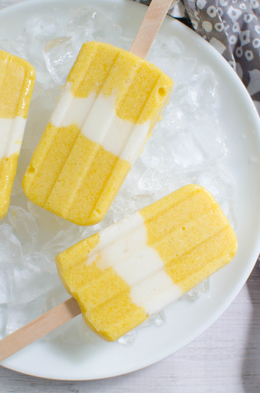 Mango Coconut Popsicles - the best way to cool off! Fresh mango is blended with coconut milk and layered with coconut yogurt! Easy, fresh, and delicious!