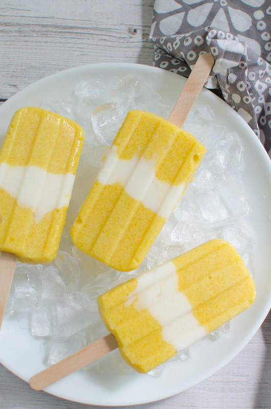 Mango Coconut Popsicles - the best way to cool off! Fresh mango is blended with coconut milk and layered with coconut yogurt! Easy, fresh, and delicious!