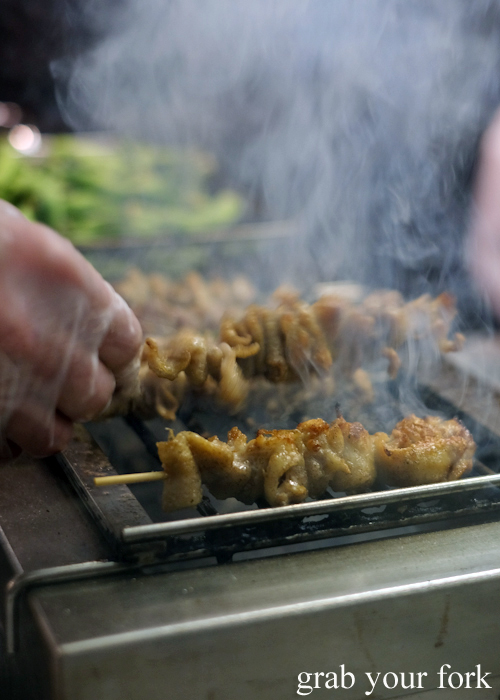 Cooking chicken skin over charcoal at Yakitori Jin Japanese restaurant in Haberfield Sydney