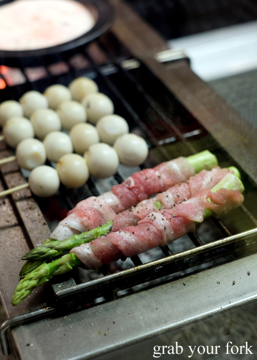 Grilling quail eggs and asparagus wrapped in bacon at Yakitori Jin Japanese restaurant in Haberfield Sydney
