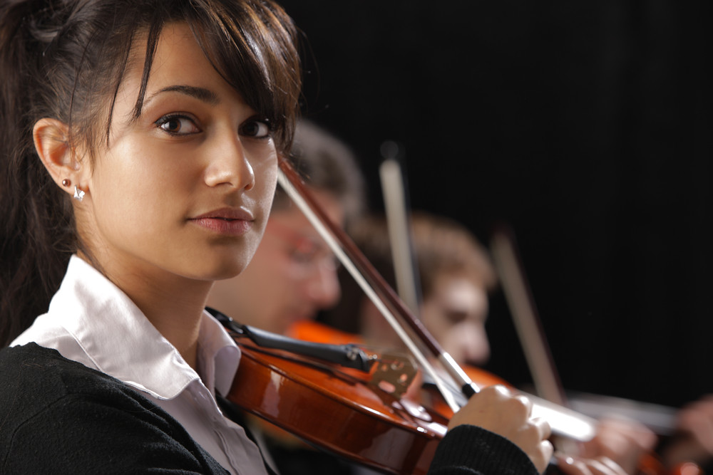 Close-up of violinist in orchestra