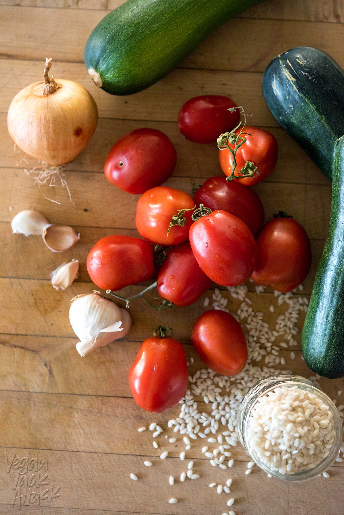 tomatoes, zucchini, onion, and garlic on a cutting board