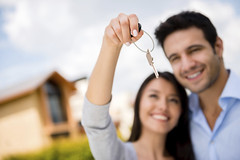 A couple holding a key to a house.