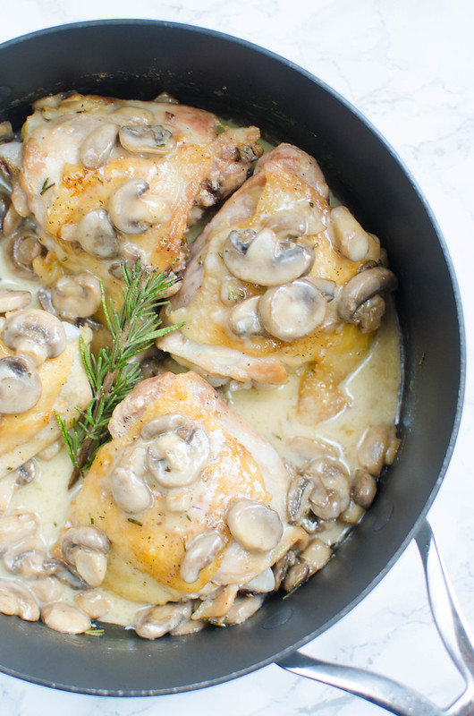 Chicken Thighs with Creamy Rosemary Mushrooms - crispy chicken thighs topped with mushrooms in a creamy sauce! Low carb, delicious, and ready in about 30 minutes!