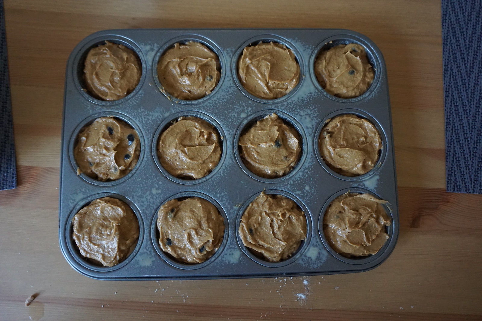 Gluten free blueberry pumpkin muffins batter poured into a muffin tin