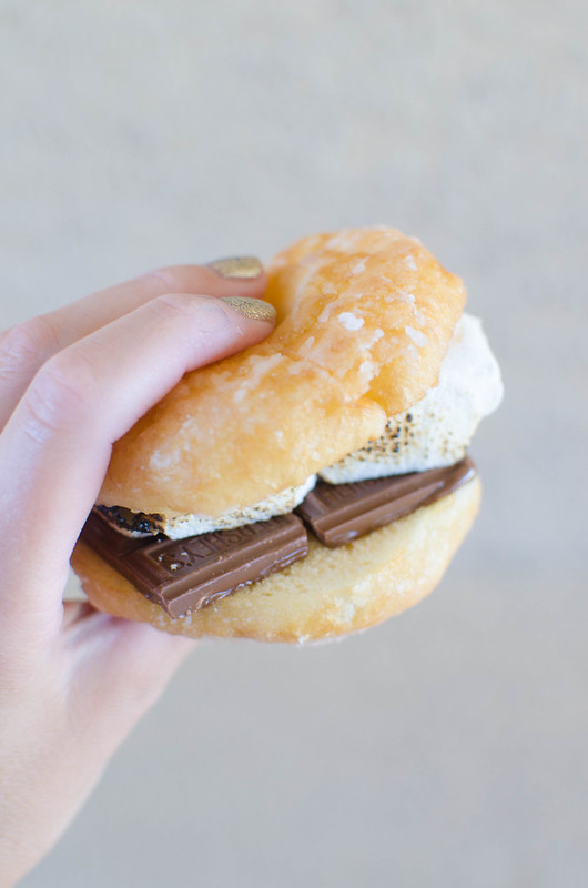 Doughnut S'mores! These are a must make for summer. Milk chocolate and toasted marshmallows on a warm glazed doughnut!
