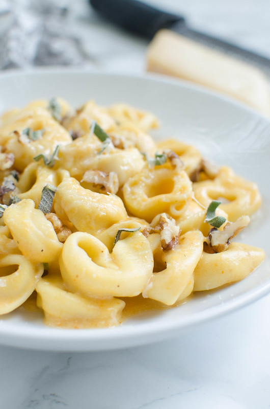 Pumpkin Alfredo Tortellini - a fall twist on the classic alfredo sauce recipe! Tossed with tortellini and sprinkled with fresh sage and walnuts. You won't be able to resist this one!