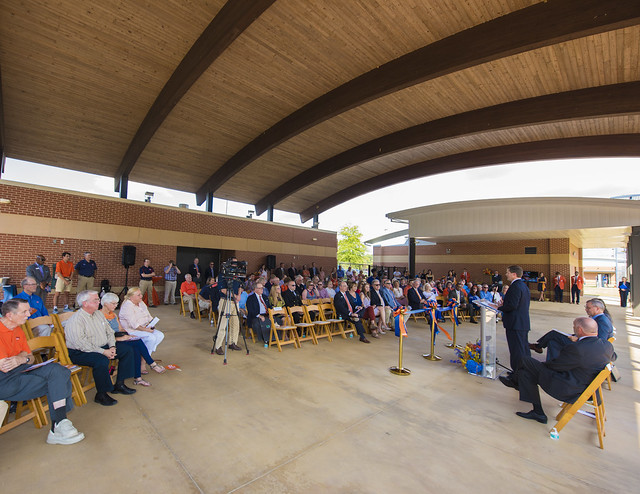 A crowd gathers under the pavilion for the ribbon cutting ceremony at the Band Practice Complex.
