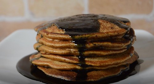 stack of Halloween themed pumpkin chocolate chip pancakes with black syrup