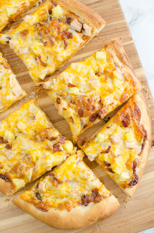 Barbecue Chicken Pizza - a delicious recipe for pizza night! Barbecue sauce, chicken, bacon, pineapple, and red onion layered with colby jack cheese!