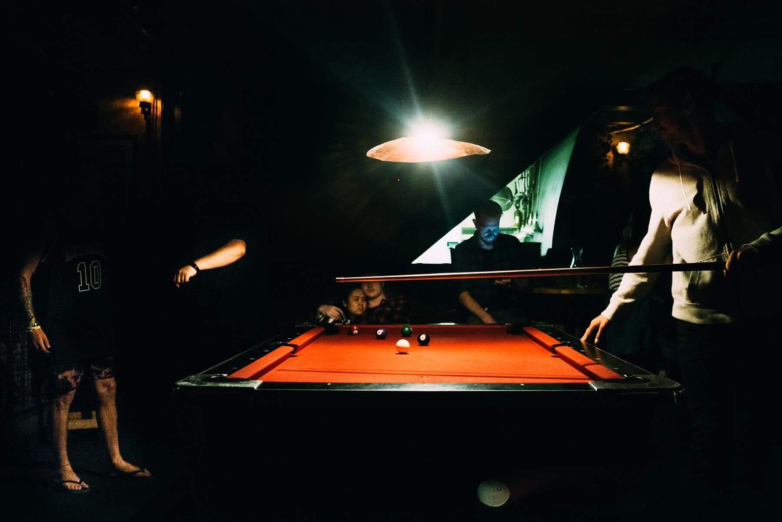 Guys around a pool table in Queenstown | by Giacomo Vesprini