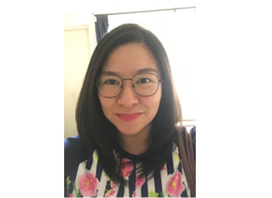 The image shows Ms. Patricia Yap wearing shirt with black and white vertical stripes with rose designs and eyeglasses with long hair below the shoulder level.