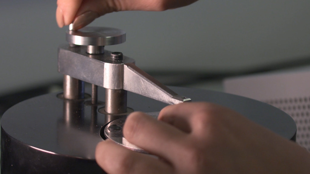 Two hands turn a metallic lever on an energy harvesting device