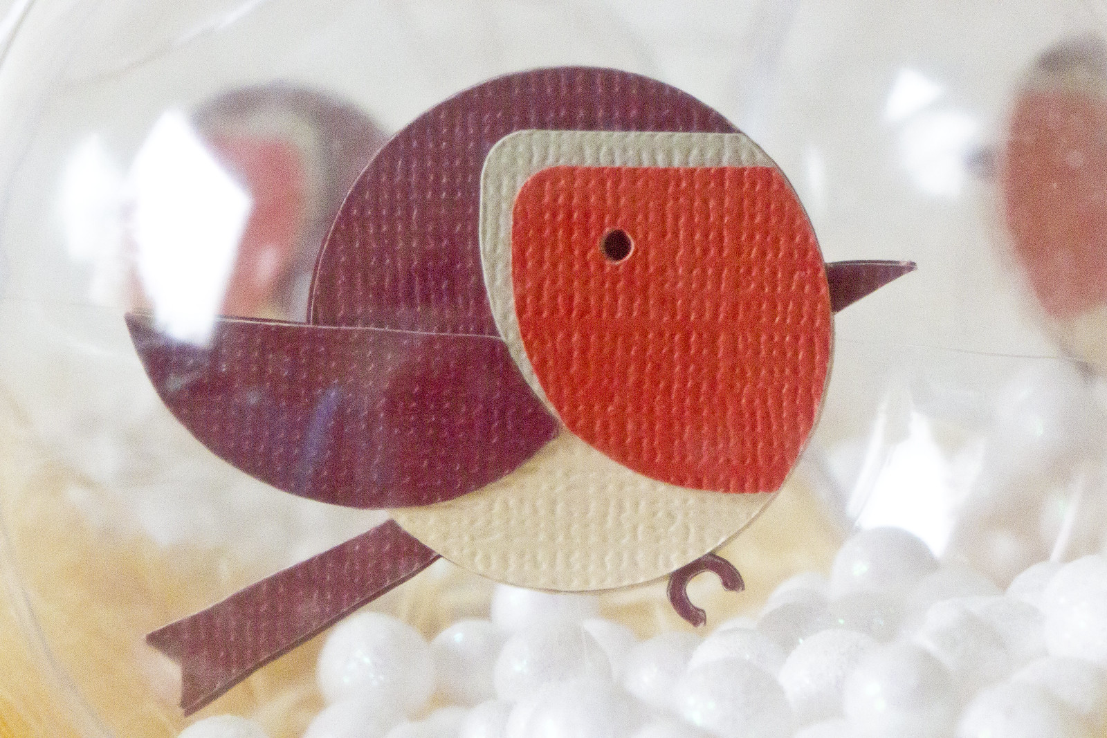 Circular paper robin in a christmas bauble decoration