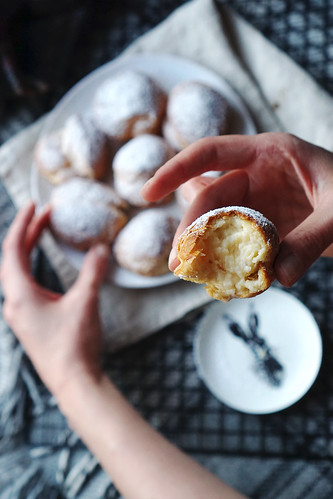 Gluten free cream puffs filled with pastry cream and covered in a dusting of icing sugar.