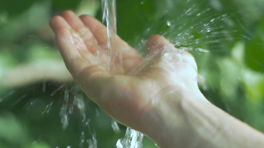 Close up of water being poured into a hand