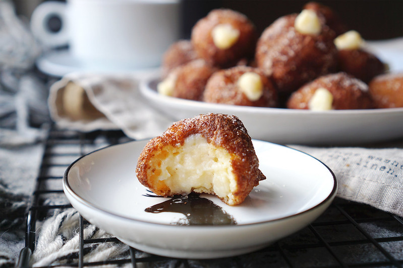 Gluten free churro donut holes rolled in cinnamon sugar and filled with hazelnut flavoured pastry cream