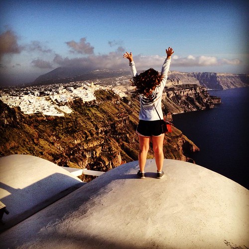 On Top of the World: A student stands on a cliff overlooking the water in Santorini, Greece.