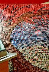 Un mur tout décoré de capsules de bouteilles de bière, de Coca ... dans un restaurant à Oliva