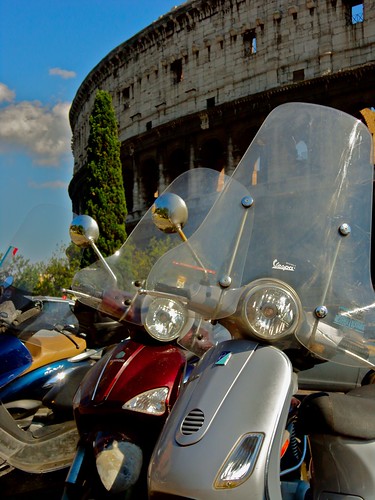 Time Warp: Modern scooters are parked in front of the classic background of the Colosseum in Rome, Italy.