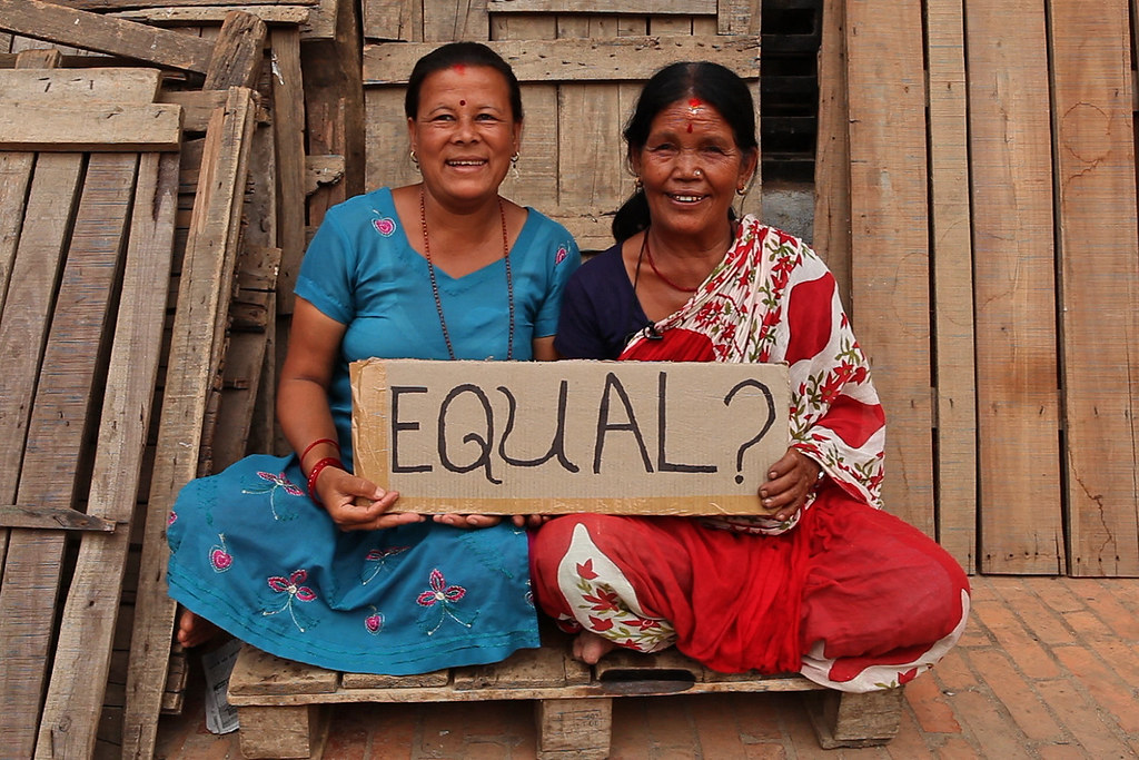 2 women holding sign with Equal? written on it