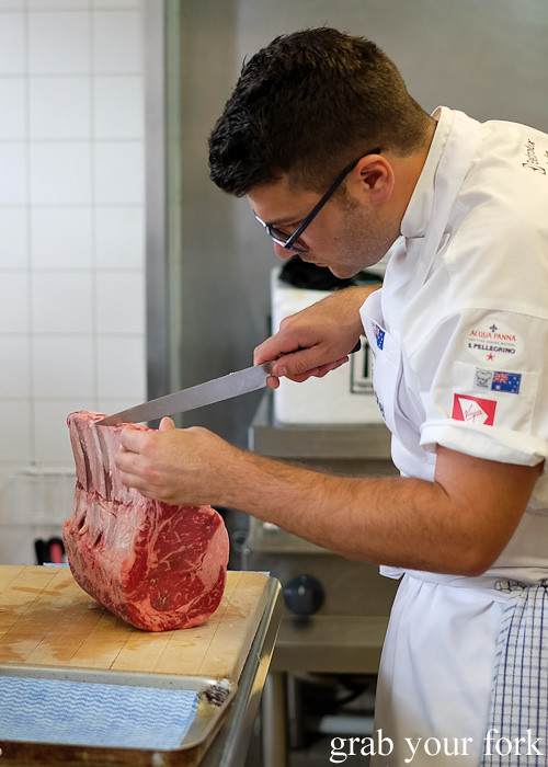 Troy Crisante from Bennelong Restaurant, Sydney carving ribeyes at the Appetite for Excellence Young Chef of the Year 2016 final cook off