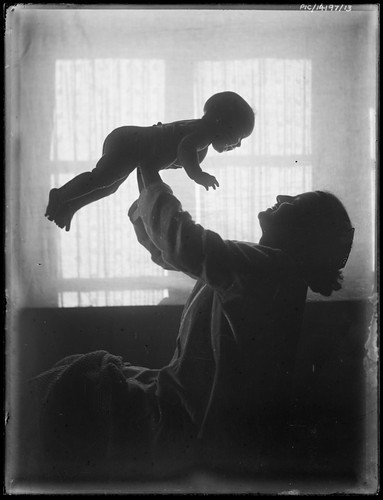 Portrait of Antoinette Hurley holding her daughter Yvonne in the air, 1921?