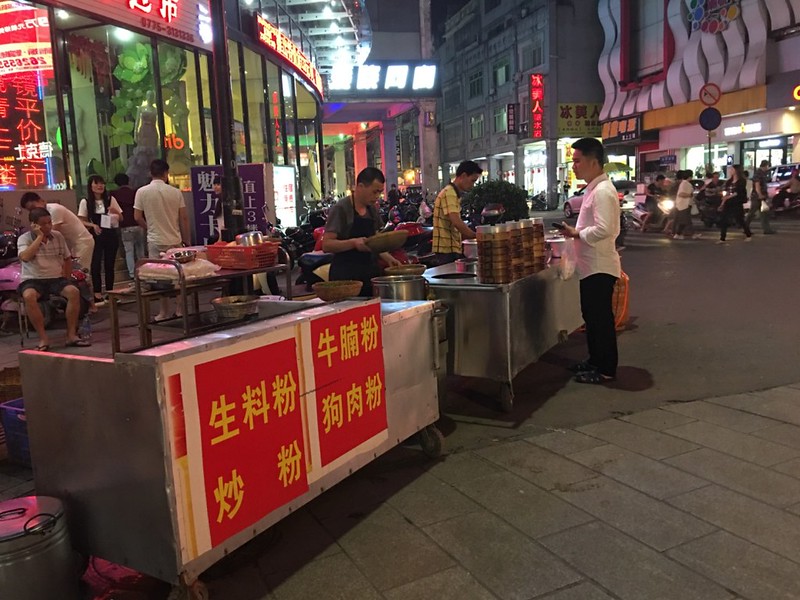 Mobile vendors on commercial pedestrian street in downtown (dog meat noodle on its menu)