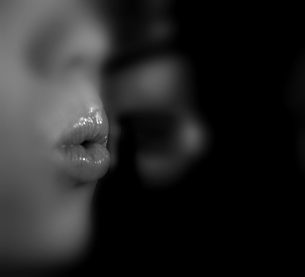 Black and white image of woman exhaling with pursed lips