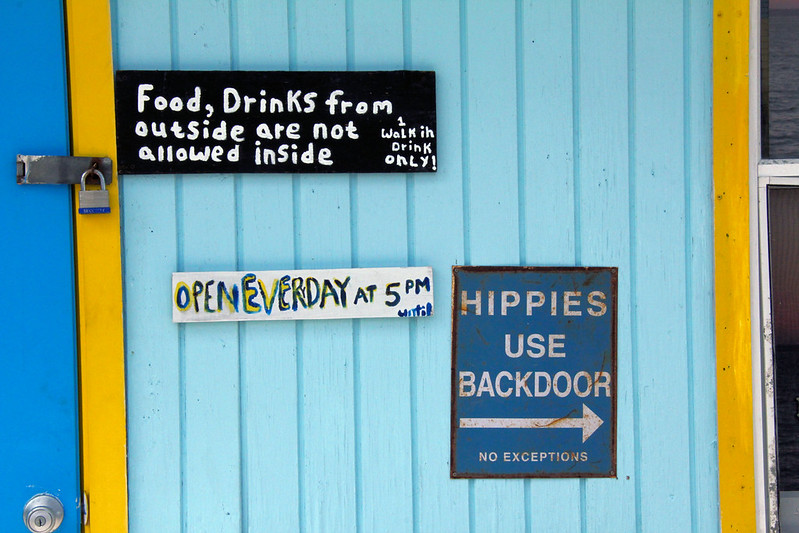 Sign: Hippies use backdoor; No Exception; Old sign informing Hippies to use the backdoor at a bar on Green Turtle Cay, Bahamas.