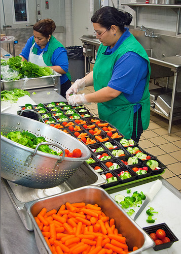 Two women preparing vegetables