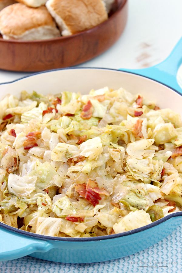 Southern Bacon-Fried Cabbage in a blue skillet with rolls.