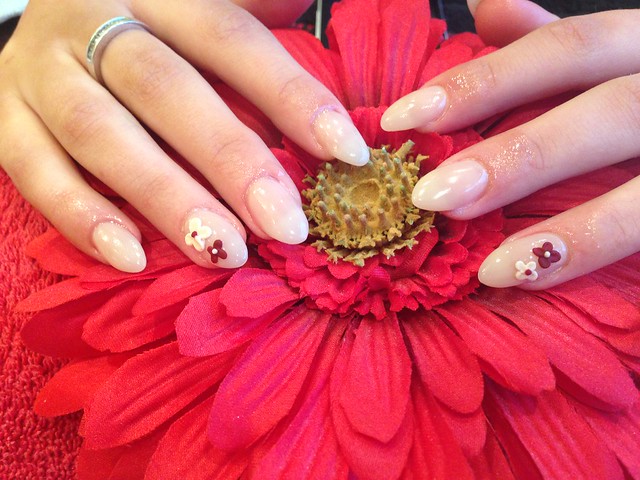Full set of acrylic nails with cream polish and 3D flower nail art