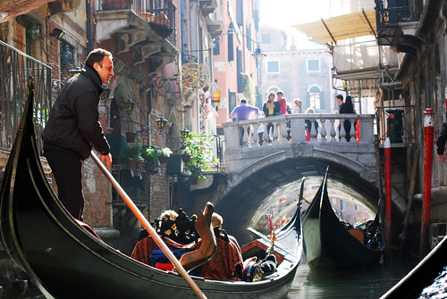 Sing Me a Song: A gondolier steers his boat through the canals in Venice, Italy.