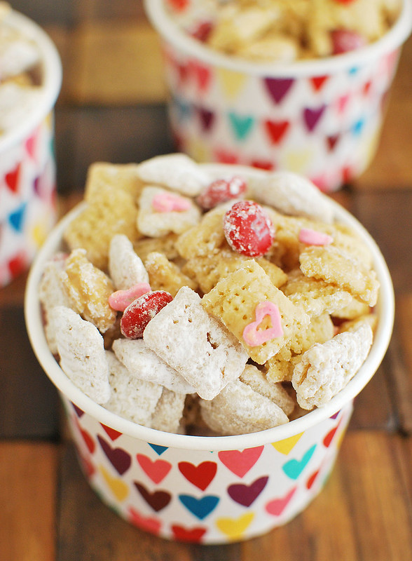 Cupid's Crunch - the cutest Valentine's Day treat! Chex cereal coated in white chocolate and peanut butter and tossed in powdered sugar. With Valentine's Day M&Ms and heart sprinkles!