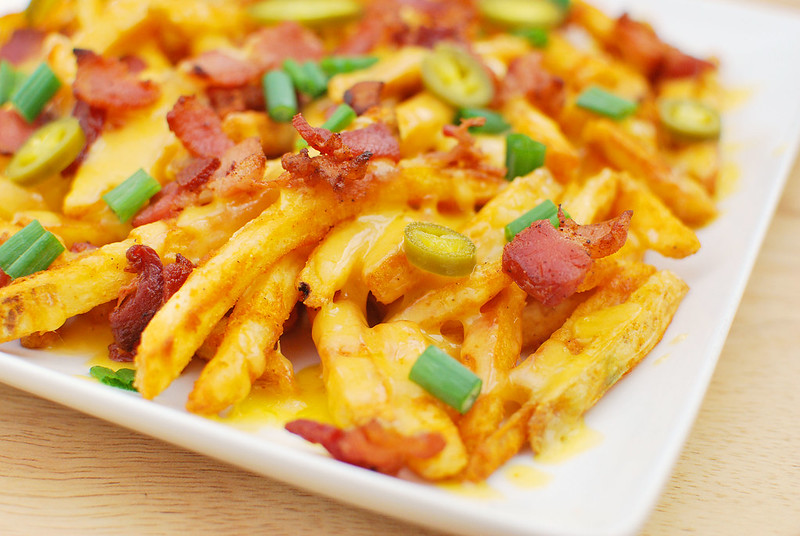 Texas Cheese Fries - seasoned fries topped with cheddar cheese, crispy bacon, green onions, and jalapenos! With a side of ranch! These are perfect for a party or a football game.