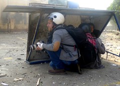 Two journalists and two children shelter from stone throwing militia