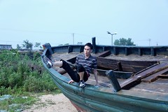 Lee on boat on beach at base of the Great Wall of China at Shan Hai Guan
