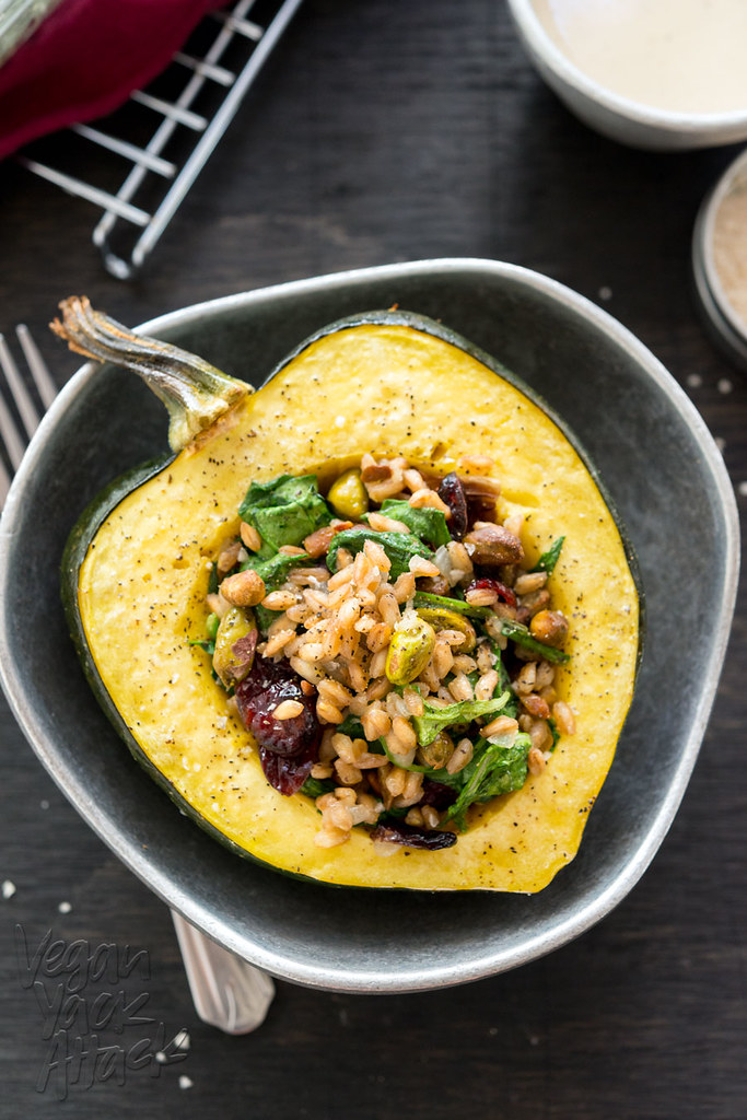 A Farro-Stuffed Acorn Squash in a pewter bowl on a black wood table