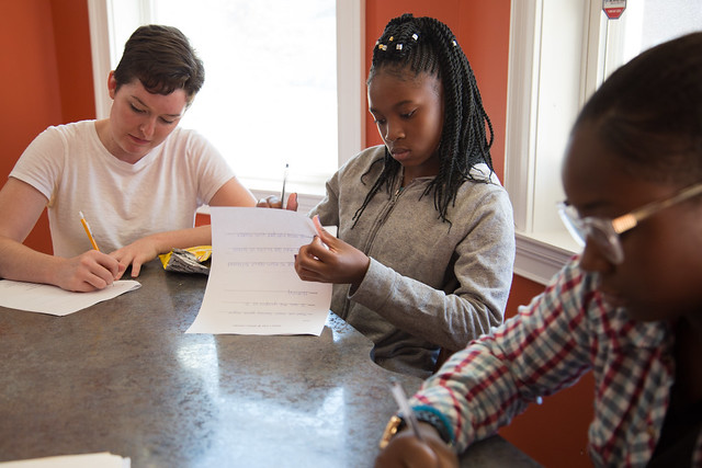 Alison Ryan, 22, left, a graduate student in SU’s School of Education, works on critical thinking questions during the Writing Our Lives Fall Kick-Off Workshop — along with Nadia Joe, 12, and Craelle Hinds, 14. | Dominique Hildebrand