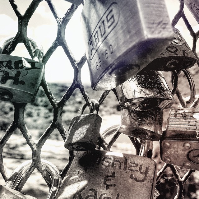 Locks secured to a balustrade at the Hartebeespoort Dam wall symbolising the security of a relationship between two people. Now we know for next time | @madewithfaded #madewithfaded #Hartebeespoort #monochrome #landscape #symbol #dam #security #Snapseed