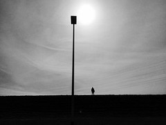a man, a pole, wires and the sun