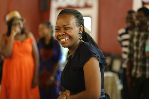 An image of workshop participants smiling and moving during an activity