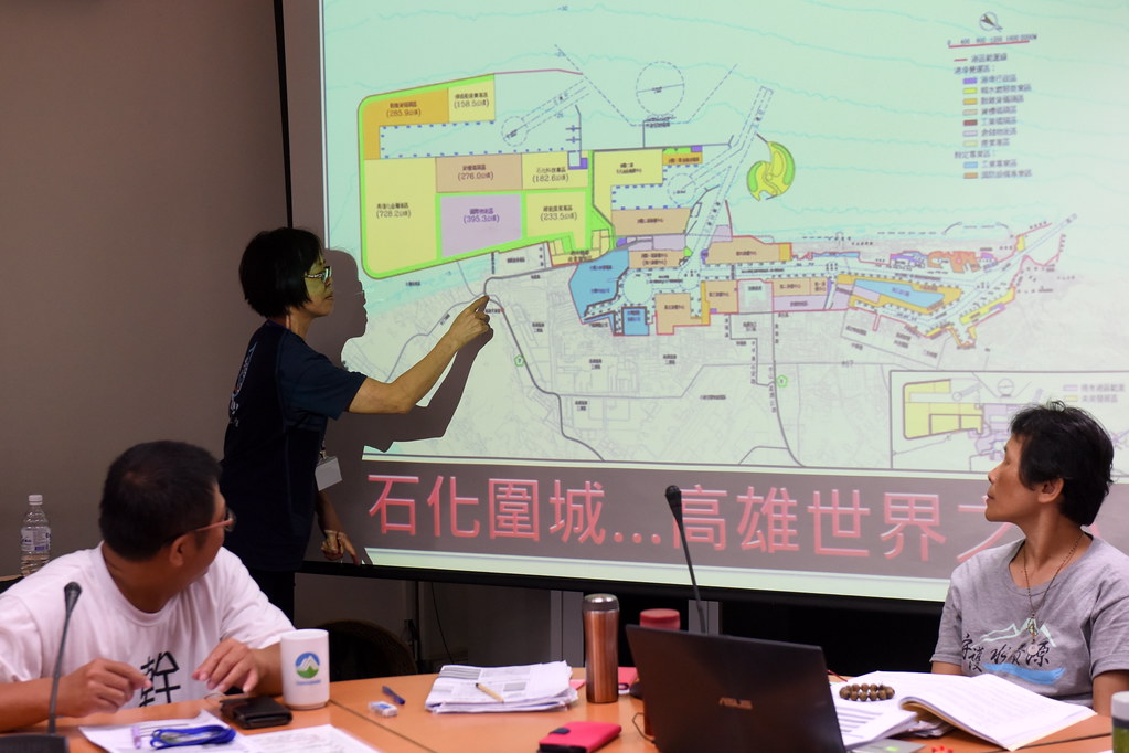 居民在會議中手指地圖強調自己所居的家園，極度鄰近圖中彩色處的開發計畫用地，飽受污染之苦。（攝影：宋小海）