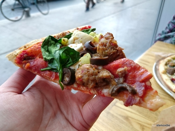 Hand holding Build-your-own Pizza slice