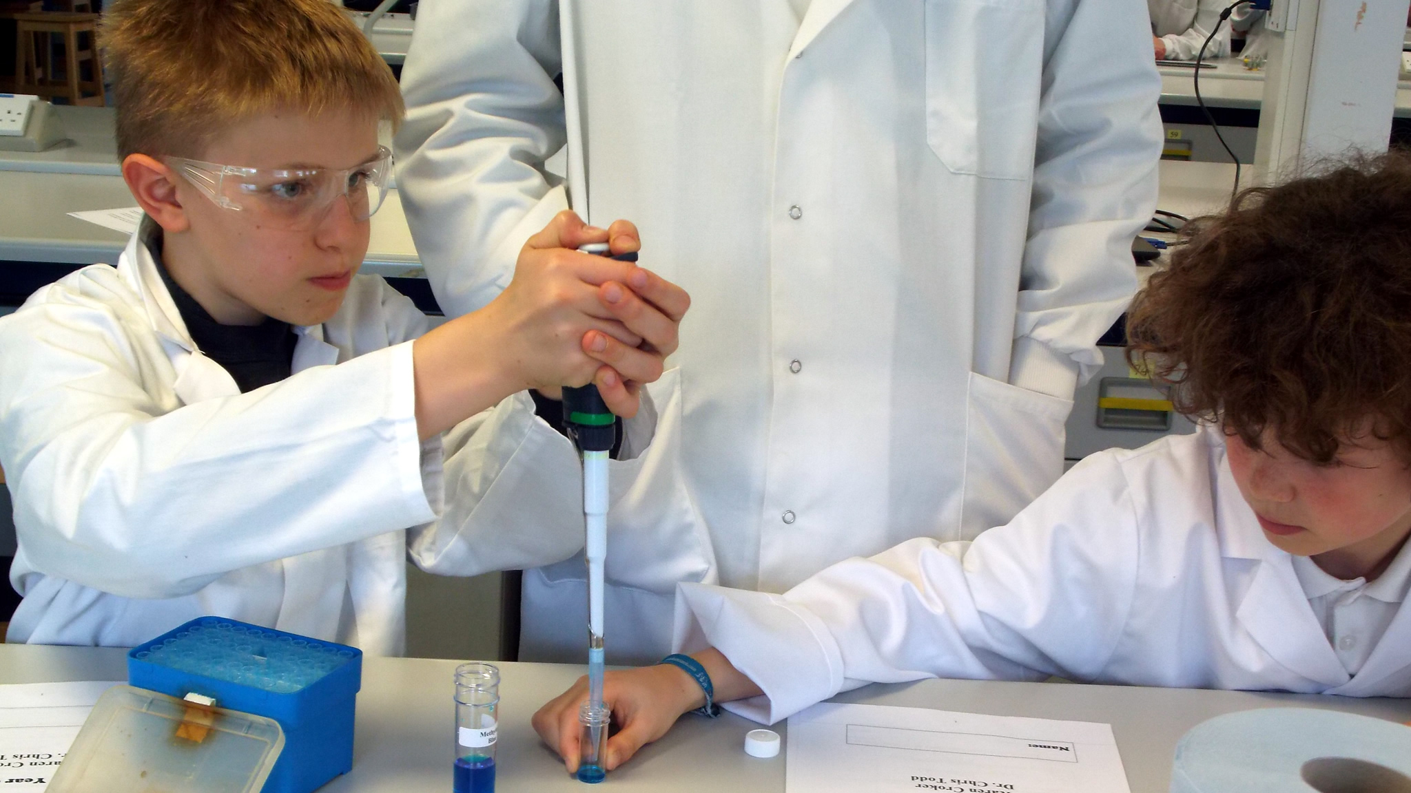 School students testing how light is absorbed by protein in solution