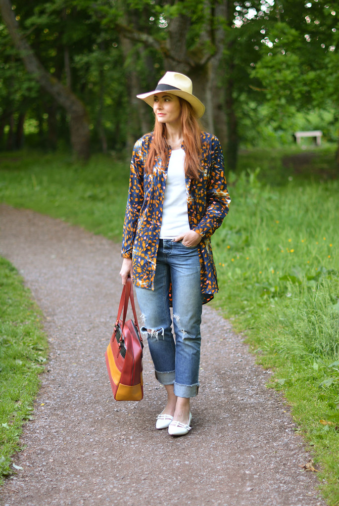 Spring style: Oversized patterned shirt, distressed jeans, straw Panama hat