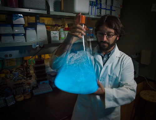 Steven Mansoorabadi with large flask of glowing dinoflagellates